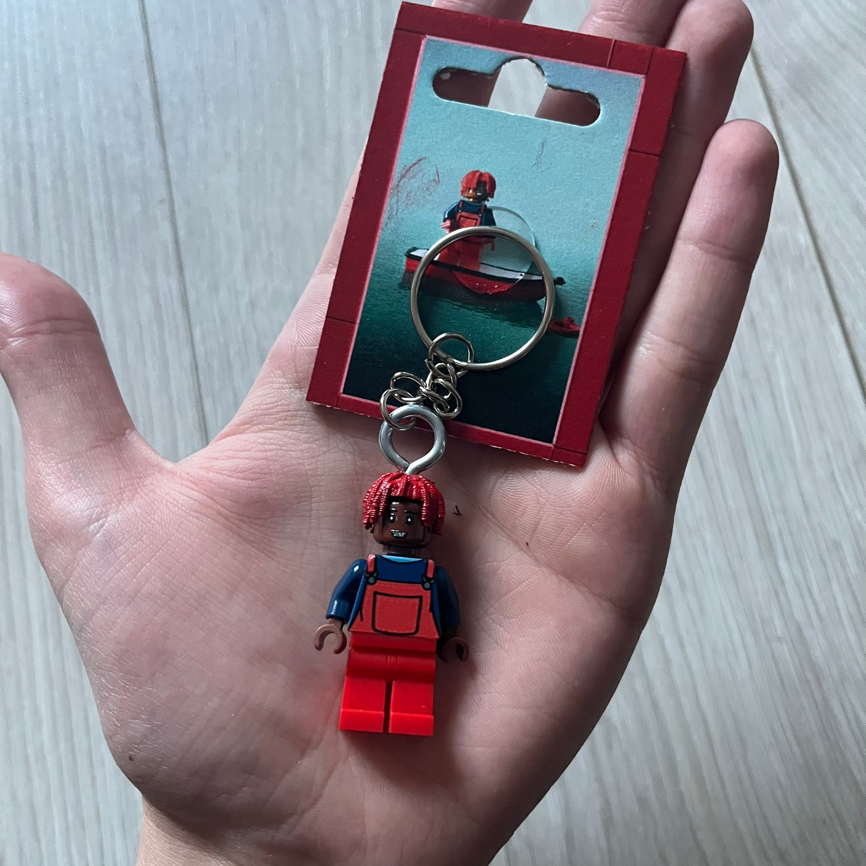 Lego Lil Yachty 'Lil Block' keychain featuring a custom Lego figure of Lil Yachty with red overalls and 3d red dreads. The figure is attached to a Lego-style recreation of the 2016 'Lil Boat' album cover, reimagined in brick graphics. A playful and creative collectible that merges music culture with fan-made Lego artistry, made by TheCanvasDon.
