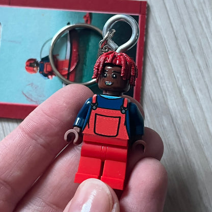 Lego Lil Yachty 'Lil Block' keychain featuring a custom Lego figure of Lil Yachty with red overalls and 3d red dreads. The figure is attached to a Lego-style recreation of the 2016 'Lil Boat' album cover, reimagined in brick graphics. A playful and creative collectible that merges music culture with fan-made Lego artistry, made by TheCanvasDon.