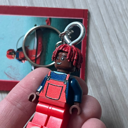 Lego Lil Yachty 'Lil Block' keychain featuring a custom Lego figure of Lil Yachty with red overalls and 3d red dreads. The figure is attached to a Lego-style recreation of the 2016 'Lil Boat' album cover, reimagined in brick graphics. A playful and creative collectible that merges music culture with fan-made Lego artistry, made by TheCanvasDon.
