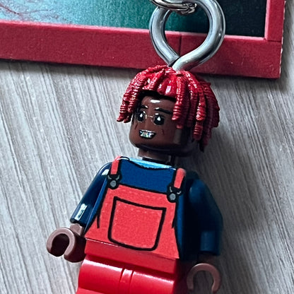 Lego Lil Yachty 'Lil Block' keychain featuring a custom Lego figure of Lil Yachty with red overalls and 3d red dreads. The figure is attached to a Lego-style recreation of the 2016 'Lil Boat' album cover, reimagined in brick graphics. A playful and creative collectible that merges music culture with fan-made Lego artistry, made by TheCanvasDon.