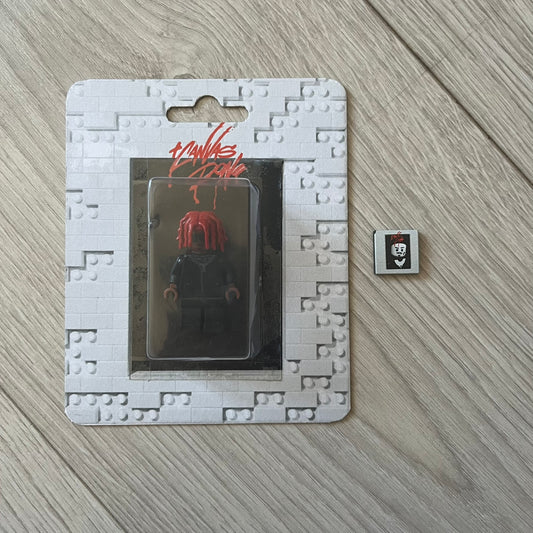 Lego Playboi Carti “Whole Lotta Red” minifigure featuring the Carti with red dreads from the album era. The figure is displayed on a paper/cartboard display accompanied by a small plate of the Lego style album cover, a limited addition only for first orders. A collectible piece from TheCanvasDon.