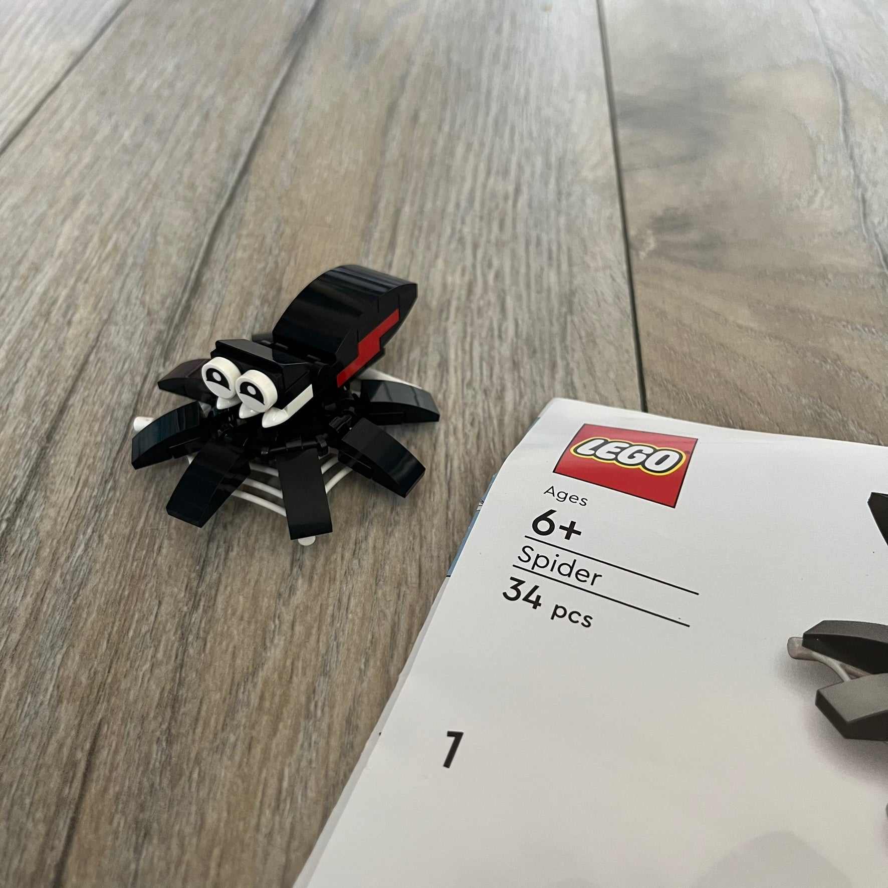 LEGO Spider Make and Take Build is a limited promotional LEGO set distributed as an exclusive “make & take” event and not available for retail purchase. The model features a black spider build with movable legs attached to a web element for display.