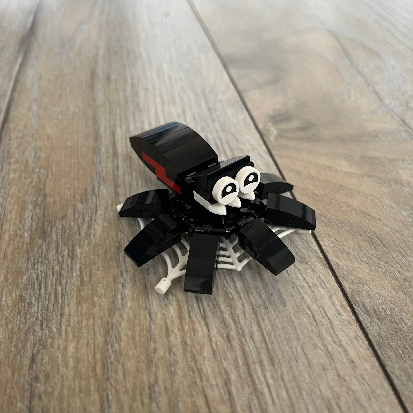LEGO Spider Make and Take Build is a limited promotional LEGO set distributed as an exclusive “make & take” event and not available for retail purchase. The model features a black spider build with movable legs attached to a web element for display.