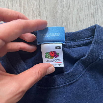 Vintage 2007 Lego Star Wars tee featuring Luke Skywalker with a lightsaber and the quote “I am a Jedi like my father before me.” Small Lego Star Wars logo sits underneath the graphic. Printed on a classic navy Fruit of the Loom blank perfect for collectors and SW fans.