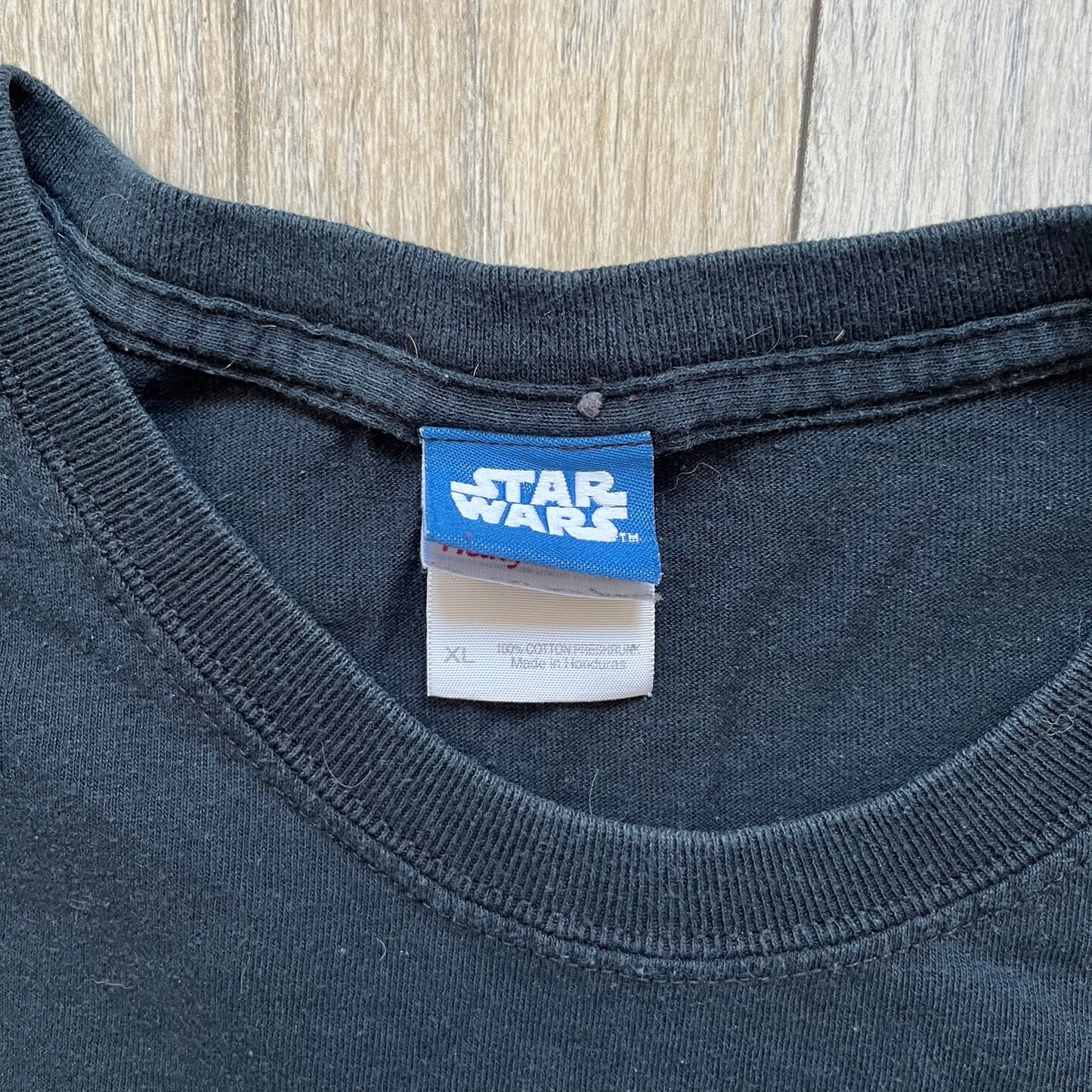 Lego Star Wars 2010 Stormtrooper Tee is a black T-shirt featuring a front graphic of a Lego Stormtrooper holding a blaster against an orange background. Below the graphic is the text “These aren’t the droids we’re looking for…” along with the Lego Star Wars logo and small 2010 licensing print.