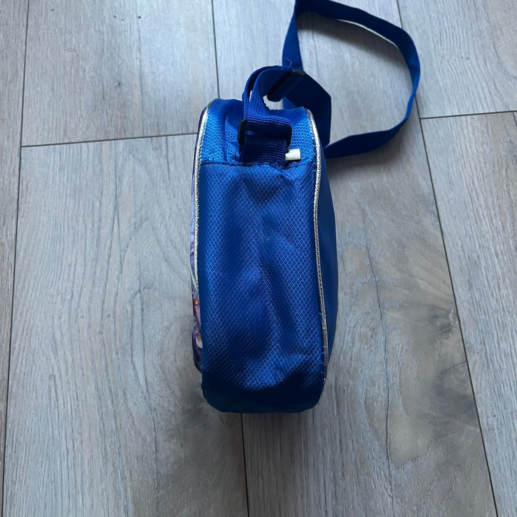 Lego Star Wars III: The Clone Wars Shoulder Bag is a blue shoulder bag featuring a raised 3D front graphic panel (not printed) with Lego Star Wars artwork. The design shows Obi-Wan Kenobi, Anakin Skywalker, and Yoda with lightsabers on a battlefield scene, with clone troopers, Ahsoka Tano, and General Grievous in the background.