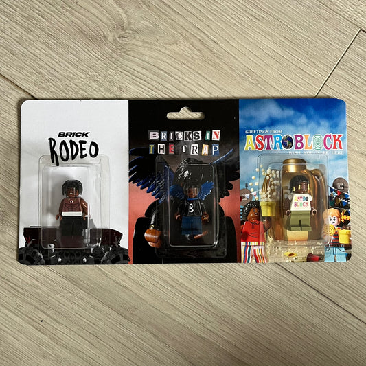 Lego Travis Scott Minifigures Triple Pack featuring three custom figures: Brick Rodeo, Bricks in the Trap, and Astroblock, each inspired and styled after Travis Scott’s iconic album eras. All three are sealed and mounted on a single display card with matching Lego album artwork, a collectible piece created by TheCanvasDon.