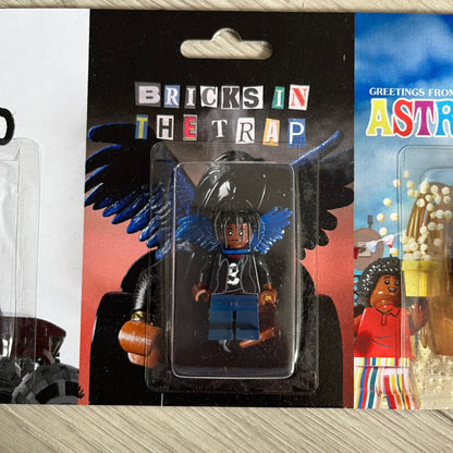 Lego Travis Scott Minifigures Triple Pack featuring three custom figures: Brick Rodeo, Bricks in the Trap, and Astroblock, each inspired and styled after Travis Scott’s iconic album eras. All three are sealed and mounted on a single display card with matching Lego album artwork, a collectible piece created by TheCanvasDon.