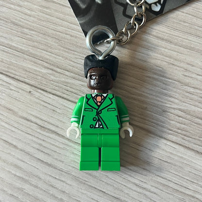Lego x Tyler, the Creator “Brickakopia” keychain featuring a custom Lego figure of Tyler in a green suit. The figure is attached to a Lego-style recreation of the 2024 Chromakopia album cover, reimagined in brick graphics. A playful and creative collectible that merges music culture with fan-made Lego artistry, made by TheCanvasDon.