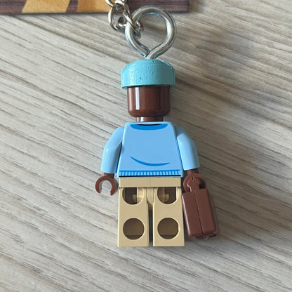 Lego x Tyler, the Creator “Call Me If You Get Block” keychain featuring a custom Lego figure of Tyler in a blue jacket with matching ushanka and suitcase. The figure is mounted on a Lego-style recreation of the 2021 Call Me If You Get Lost album cover, reimagined entirely in brick graphics. A unique collectible that blends music culture with playful Lego-inspired design, made by TheCanvasDon.