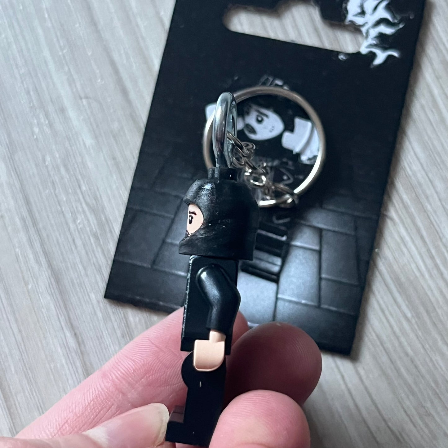 Lego Yeat 'Brick Lyfe' keychain featuring a custom Lego figure of Yeat with his black jacket and a black balaclava. The figure is attached to a Lego-style recreation of the 2022 Lyfe EP cover, reimagined in brick graphics. A playful and creative collectible that merges music culture with fan-made Lego artistry, made by TheCanvasDon.