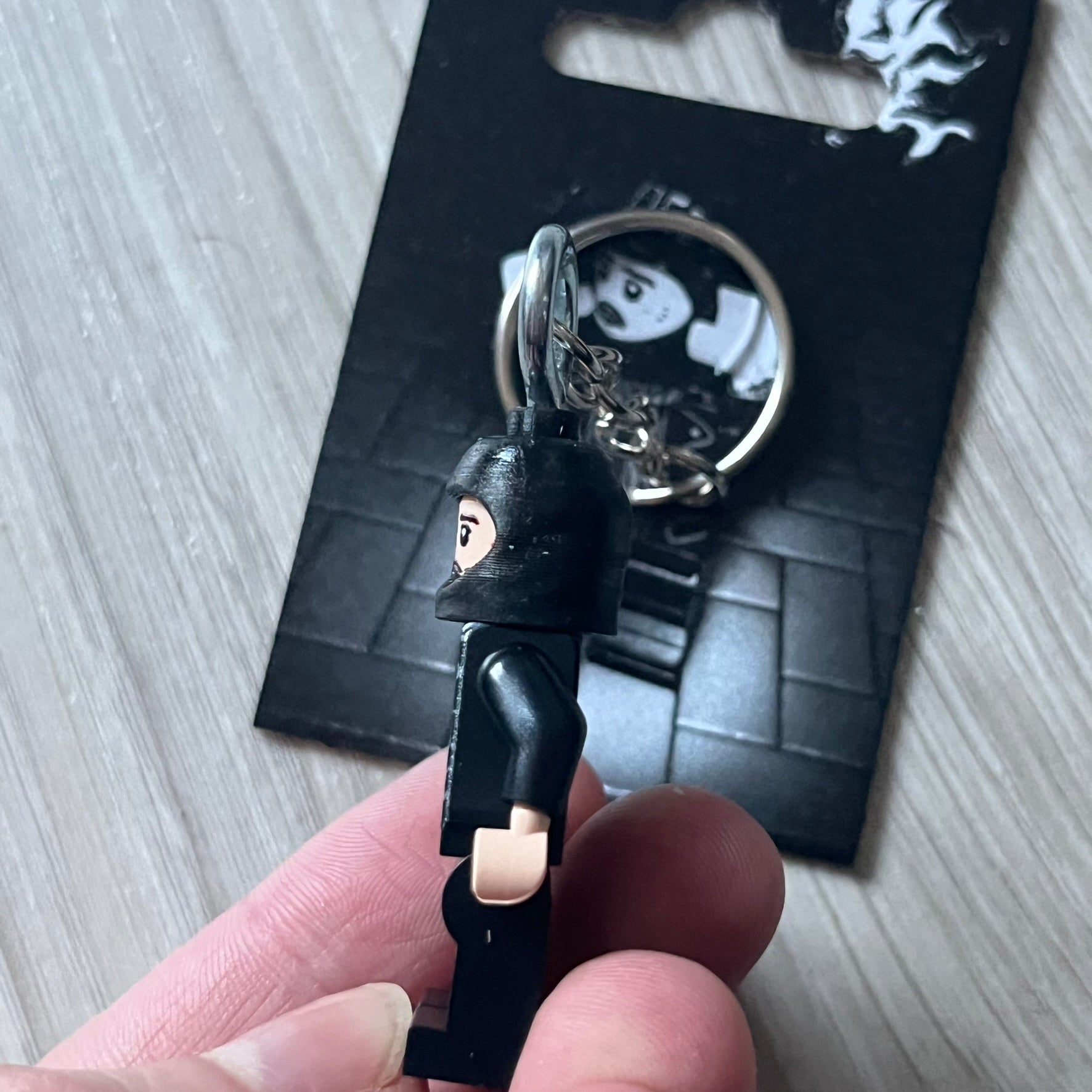 Lego Yeat 'Brick Lyfe' keychain featuring a custom Lego figure of Yeat with his black jacket and a black balaclava. The figure is attached to a Lego-style recreation of the 2022 Lyfe EP cover, reimagined in brick graphics. A playful and creative collectible that merges music culture with fan-made Lego artistry, made by TheCanvasDon.