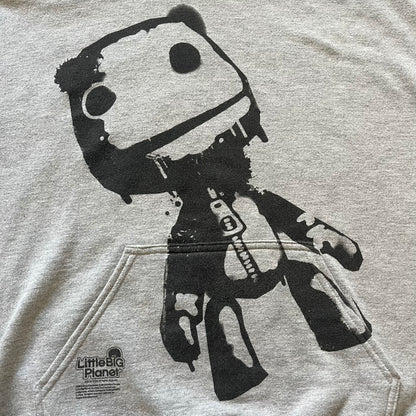 Ultra-rare Little Big Planet hoodie from 2010, made on a Gildan Heavy Blend. Showcases a graffiti like print with Sackboy and logo LBP branding on the pocket with Sony/SCEE licensing. This piece is nearly impossible to find today, making it a standout collectible for fans.
