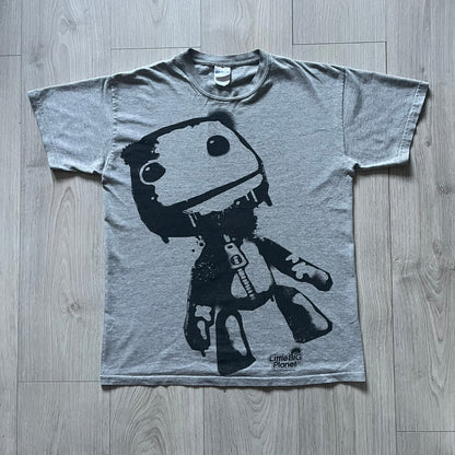 Very-rare Little Big Planet t-shirt from 2010, made on a Gildan Ultra Cotton. Showcases a graffiti like print with Sackboy and LBP logo branding in the bottom right corner with Sony/SCEE licensing. One of the rarest LBP pieces, this t-shirt is a true grail for fans and collectors.