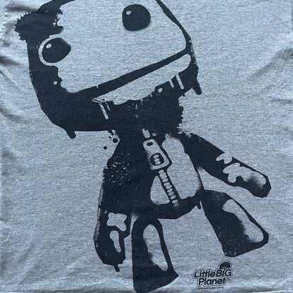 Very-rare Little Big Planet t-shirt from 2010, made on a Gildan Ultra Cotton. Showcases a graffiti like print with Sackboy and LBP logo branding in the bottom right corner with Sony/SCEE licensing. One of the rarest LBP pieces, this t-shirt is a true grail for fans and collectors.