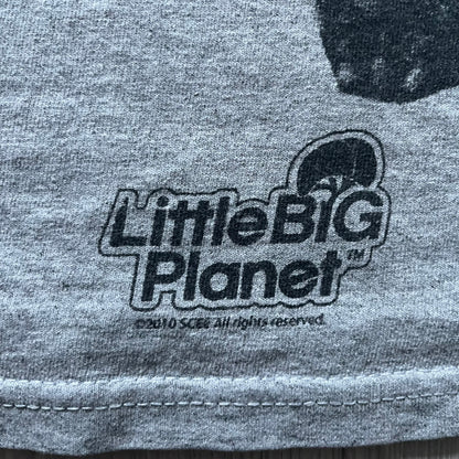 Very-rare Little Big Planet t-shirt from 2010, made on a Gildan Ultra Cotton. Showcases a graffiti like print with Sackboy and LBP logo branding in the bottom right corner with Sony/SCEE licensing. One of the rarest LBP pieces, this t-shirt is a true grail for fans and collectors.