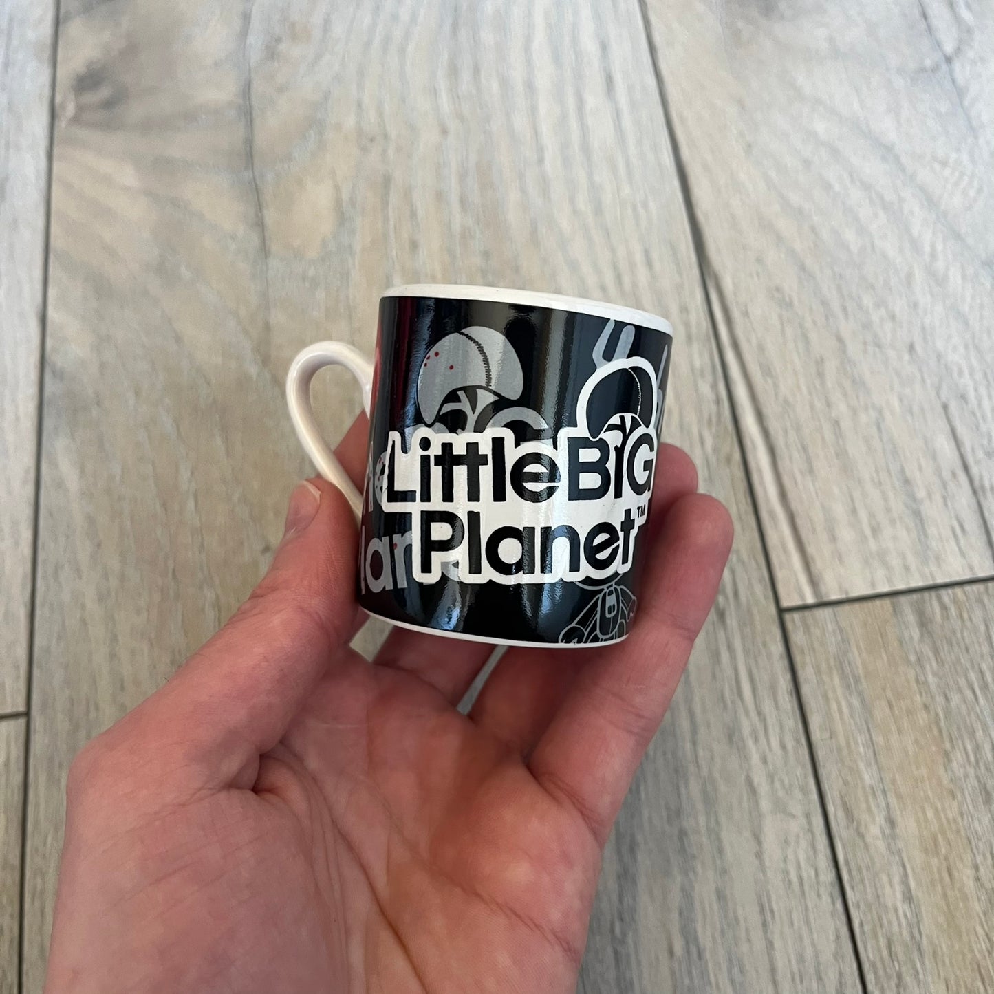 LittleBigPlanet 2011 Collectable Mini Mugs + Saucers Set is a 4-piece espresso set featuring characters from the LittleBigPlanet series, including Sackboy, Marvin the Disco Dancer, Gloria, and Yuri Army Sackboy. Each mini mug includes a wraparound character graphic with the LittleBigPlanet logo and comes with a matching saucer printed on the top. The set is officially licensed by Sony Computer Entertainment, includes a display box, and carries SCEE 2011 licensing on the base of the mugs and saucers.