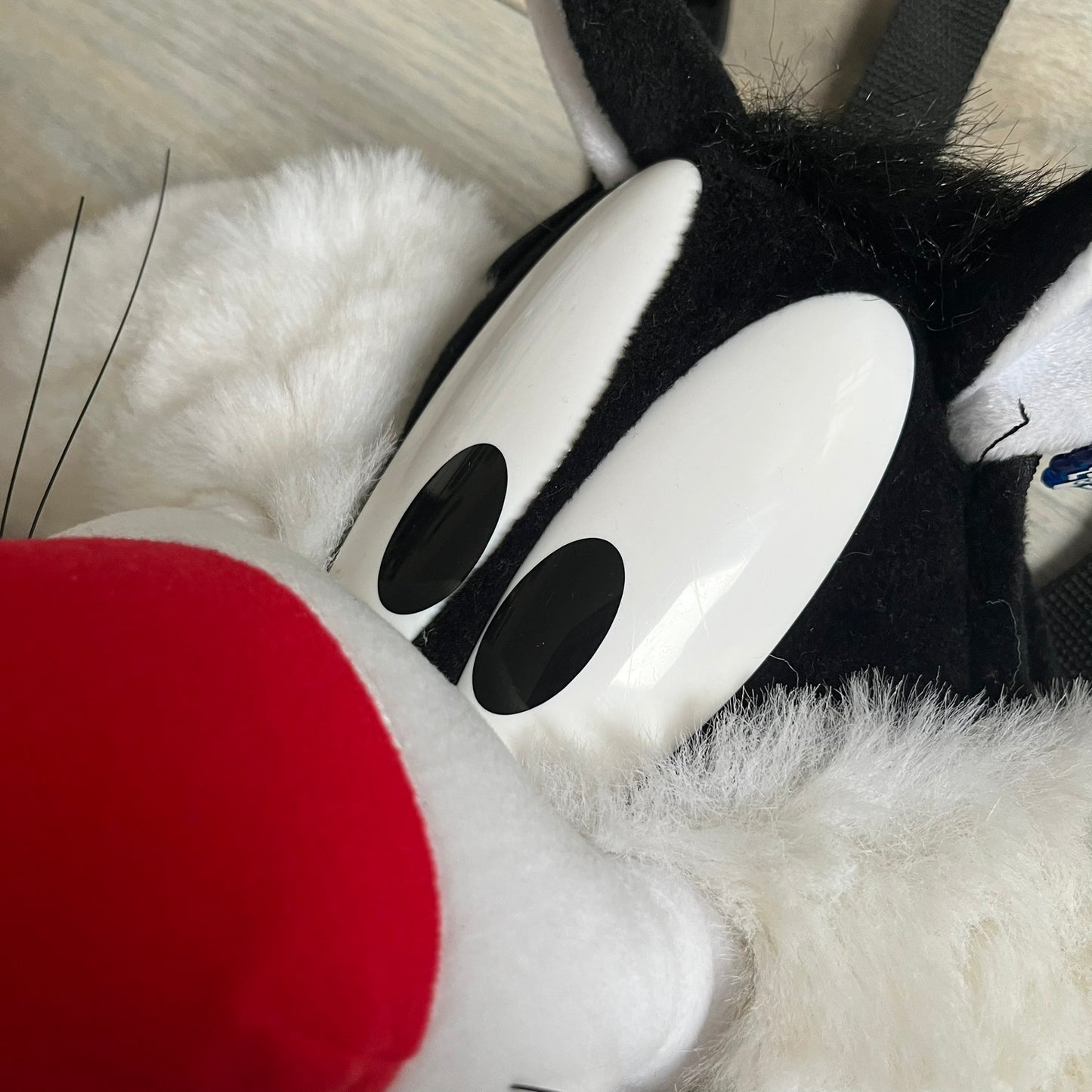 Looney Tunes 1996 Sylvester Head Backpack is a backpack shaped like Sylvester’s head. It features a furry exterior, white plastic eyes, a red nose, and detailed character features throughout. The backpack includes black shoulder straps, a blue plastic Warner Bros. tag, and a 1996 licensing tag.