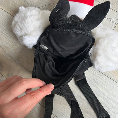 Looney Tunes 1996 Sylvester Head Backpack is a backpack shaped like Sylvester’s head. It features a furry exterior, white plastic eyes, a red nose, and detailed character features throughout. The backpack includes black shoulder straps, a blue plastic Warner Bros. tag, and a 1996 licensing tag.