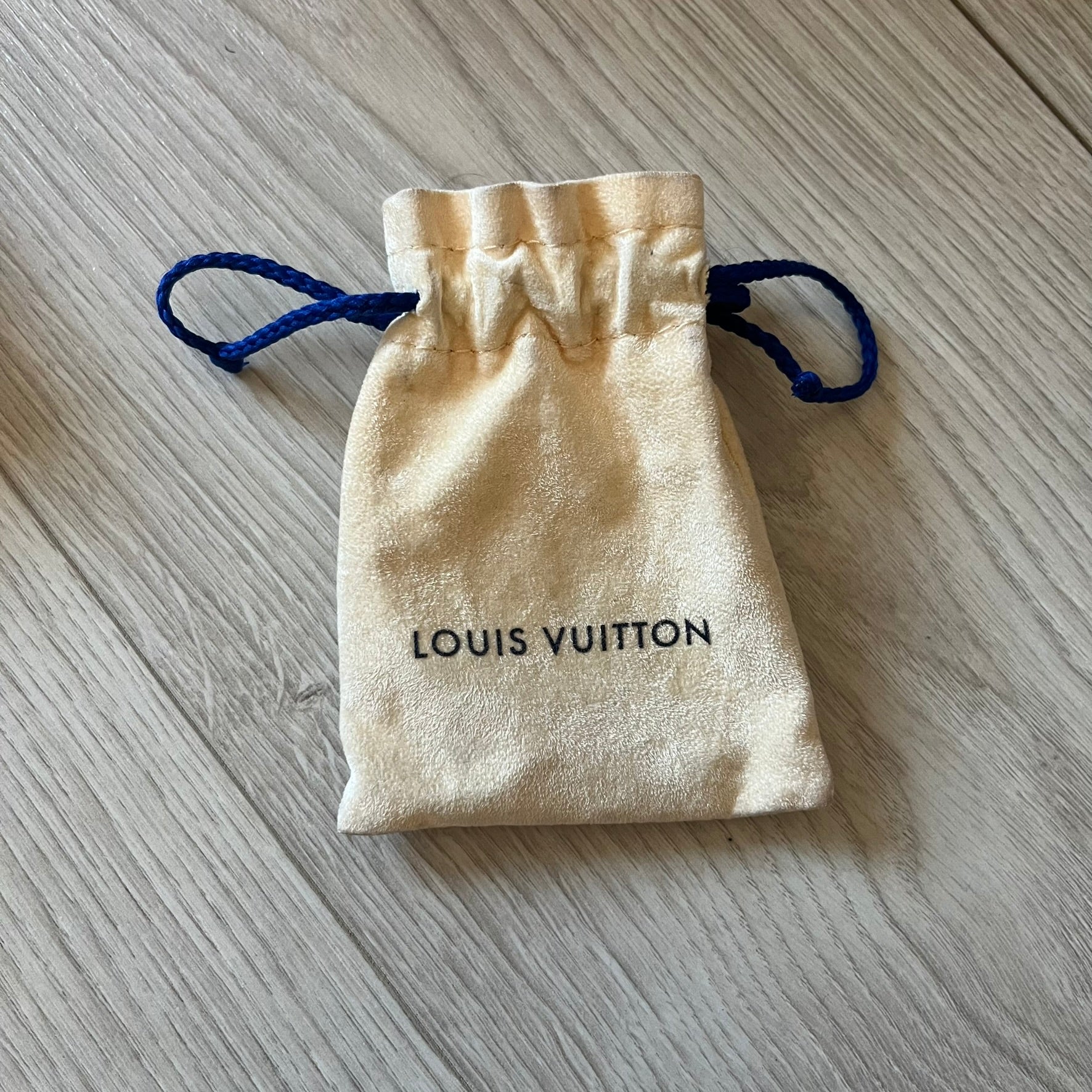 Louis Vuitton drawstring pouch on a wooden surface