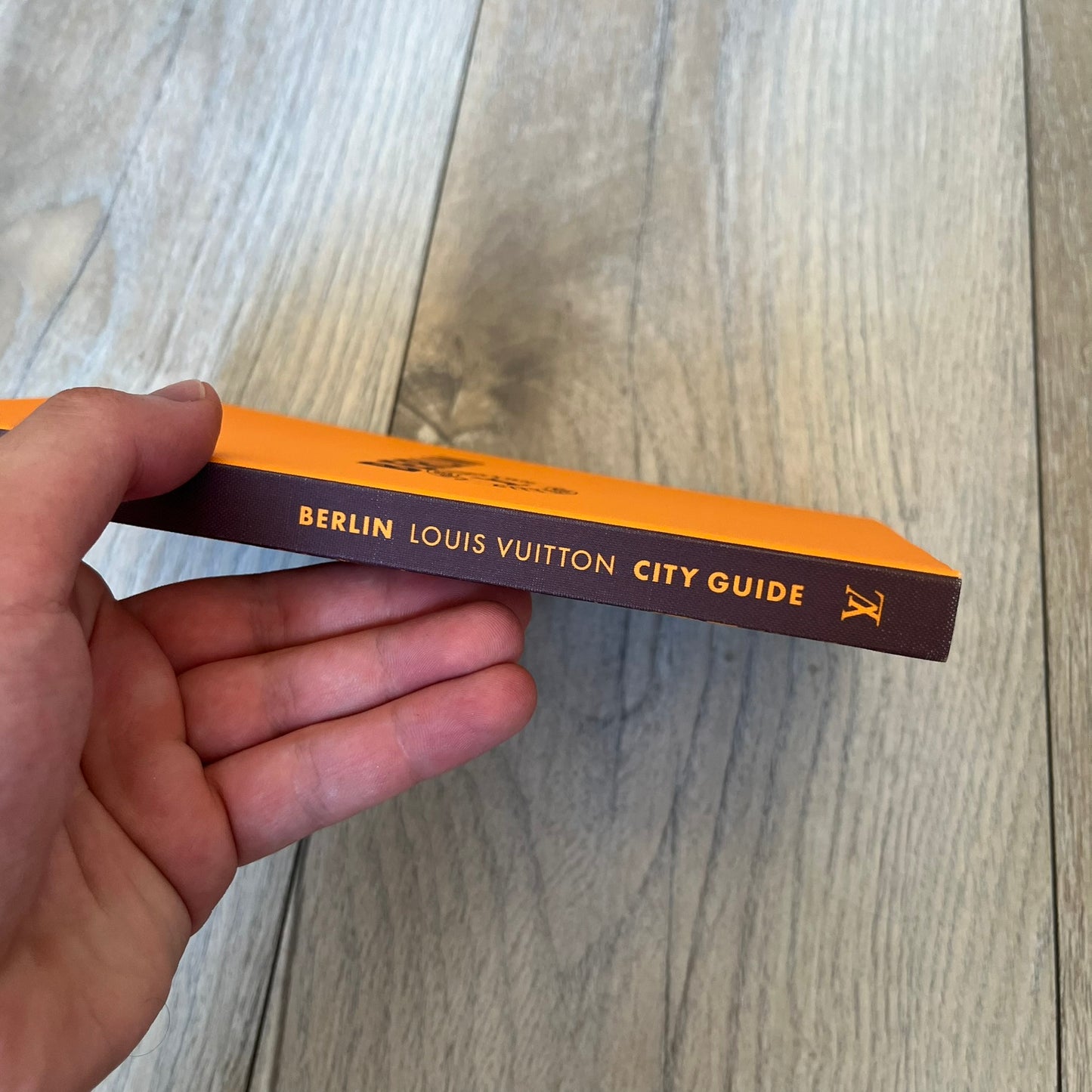Louis Vuitton Berlin City Guide is an English-language travel guide with a cloth-bound hardcover. It includes recommendations for hotels, restaurants, museums, shopping, and cultural attractions throughout Berlin. The edition features guest contributions by Bénédicte Savoy, writing by Romain Charbon and Tristan Sechrest, and exclusive photography by Thierry Ardouin.