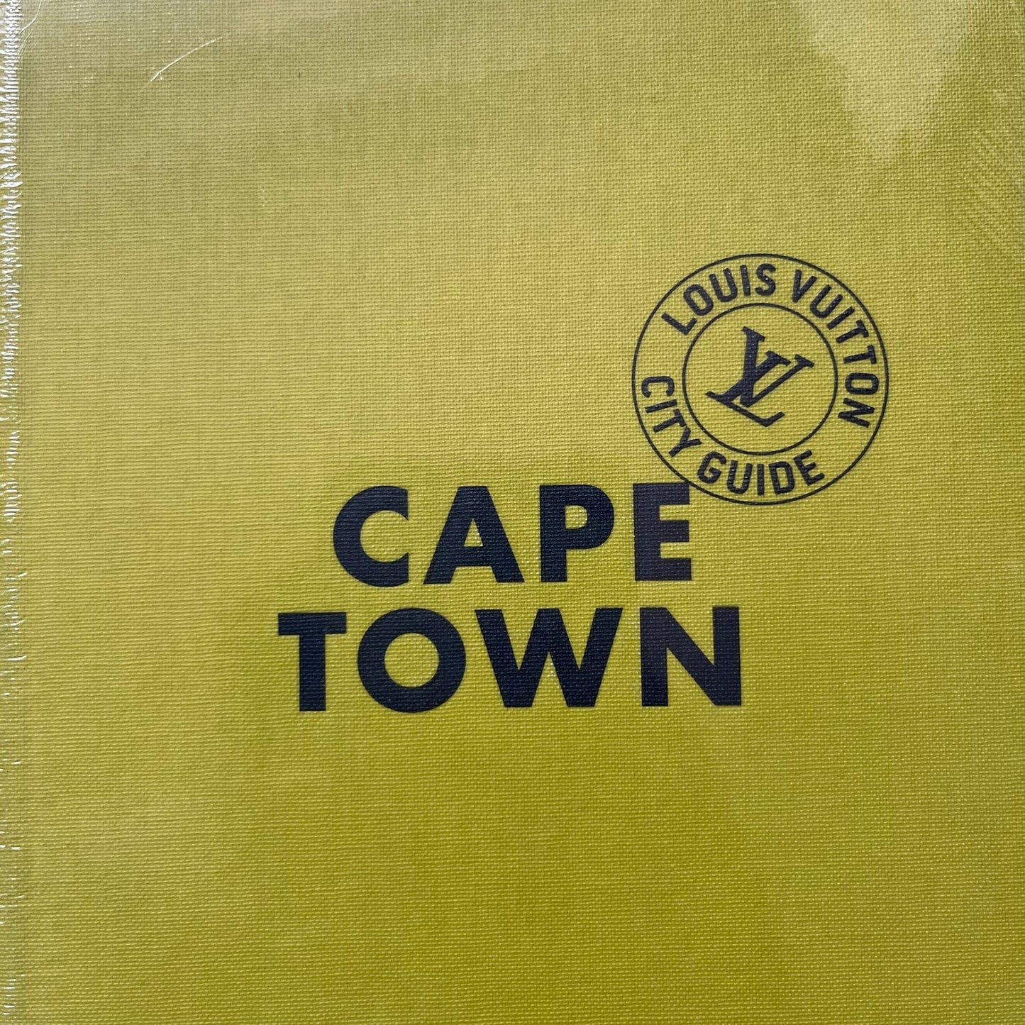 Louis Vuitton “Cape Town” City Guide is an English-language travel book with cloth binding, featuring contributions from writers Paul Duncan and Pnina Fenster. The guide includes a special guest contribution from Justin Fox, with exclusive photography by Grégoire Eloy. It covers Cape Town’s hotels, restaurants, cultural landmarks, and creative hubs, offering curated insights into the city’s art, design, gastronomy, and culture.