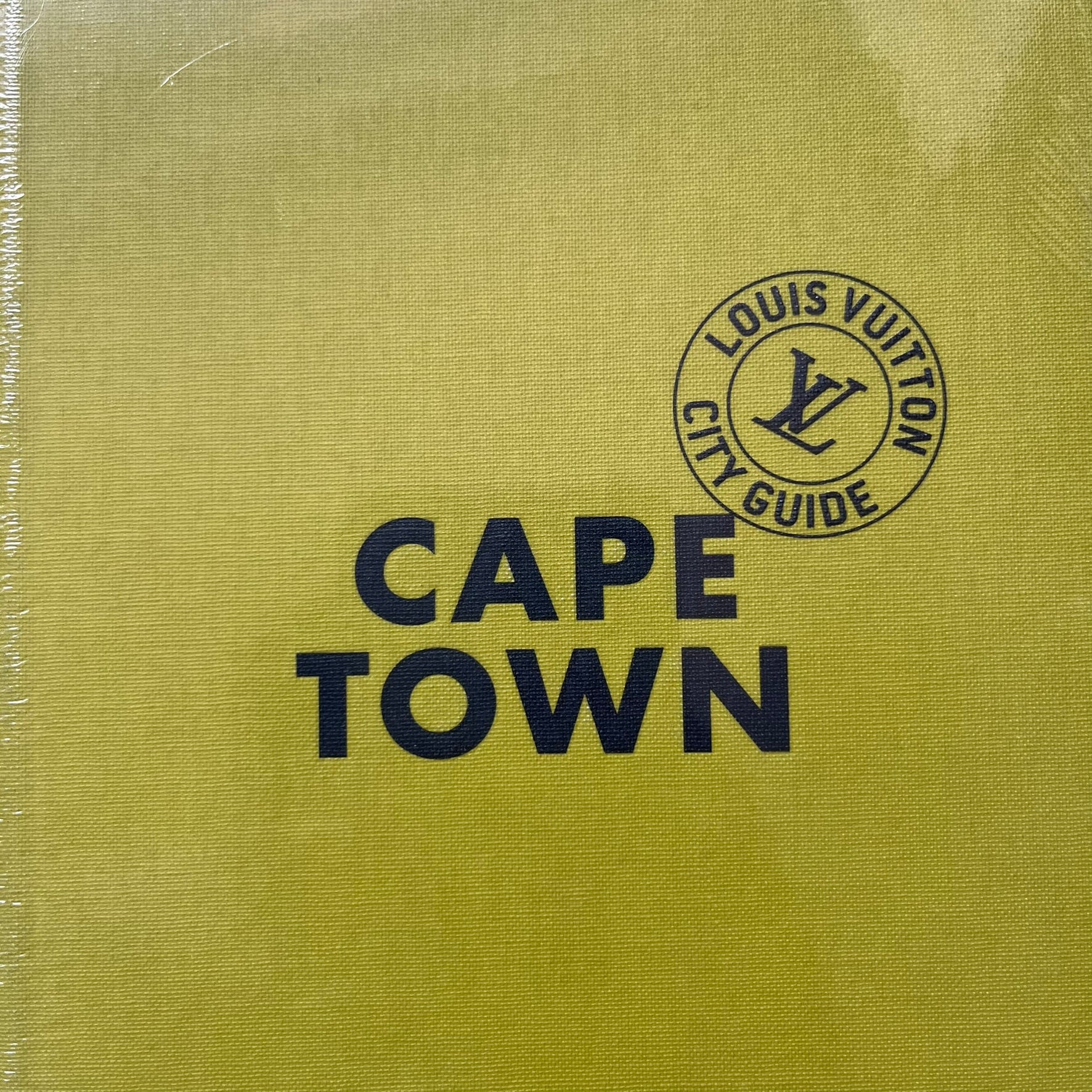 Louis Vuitton “Cape Town” City Guide is an English-language travel book with cloth binding, featuring contributions from writers Paul Duncan and Pnina Fenster. The guide includes a special guest contribution from Justin Fox, with exclusive photography by Grégoire Eloy. It covers Cape Town’s hotels, restaurants, cultural landmarks, and creative hubs, offering curated insights into the city’s art, design, gastronomy, and culture.