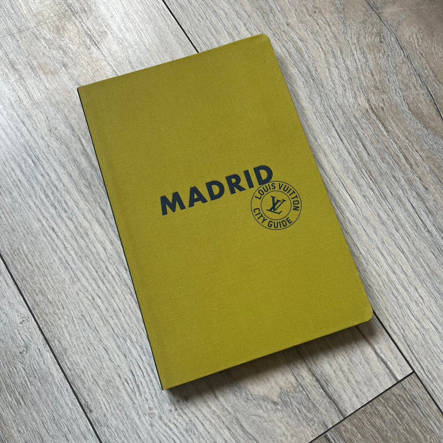 Louis Vuitton “Madrid” City Guide is a 320-page English-language travel book with cloth binding. It features contributions from writers Stephen Phelan, Ian Mount, Michael Stothard, and Joanna Wivell, with a special guest contribution from Sara Hurtado. Photography is provided by Mat Jacob of the Tendance Floue collective, offering curated insights into Madrid’s hotels, restaurants, cultural landmarks, and creative hubs