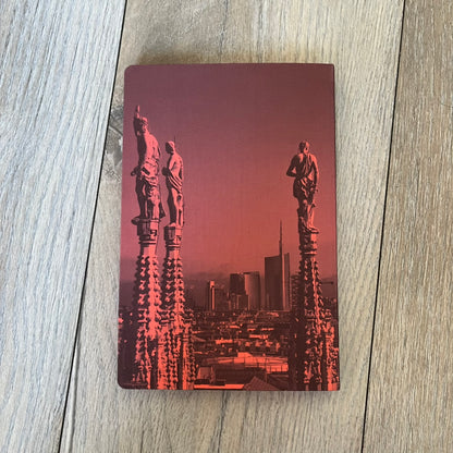 Louis Vuitton *Milan* City Guide is an English-language travel guide with a cloth-bound hardcover. It features recommendations for hotels, restaurants, museums, shopping, and cultural attractions throughout Milan. The edition includes guest contributions by Mahmood, writing by Pierre Léonforte, Corrado Beldi, Katia Kulawick-Assante, and Isabelle Valembras Dahirel, along with exclusive photography by Denis Bourges.
