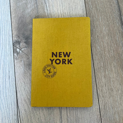 Louis Vuitton “New York” City Guide is an English-language travel book with cloth binding, featuring contributions from writers Carole Sabas, Marie Salomé Peyronnel, Aude Revier, and Fabrice Gaucher. The guide includes special guest contributions from Hank Willis Thomas and Rujeko Hockley, with exclusive photography by Pascal Aimar. It covers New York’s hotels, restaurants, cultural landmarks, and creative hubs, providing curated insights into the city’s art, design, gastronomy, and culture.