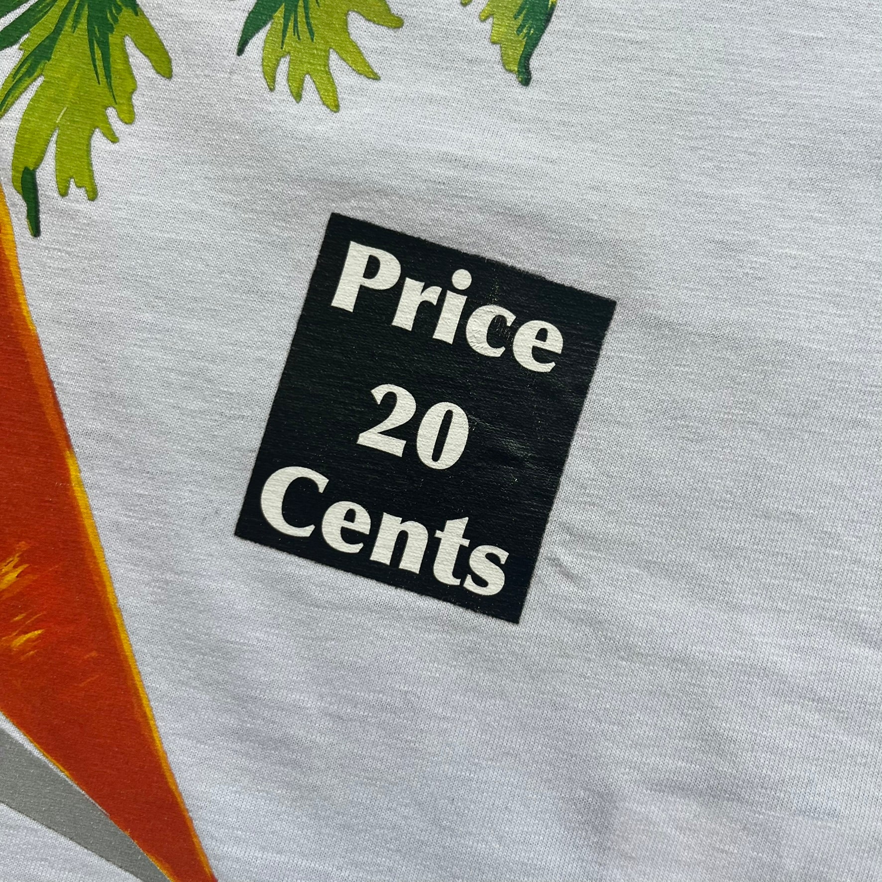 Love Moschino 2010s Carrot Tee is a black and white T-shirt with black sleeves and back panel. The front features Love Moschino branding above two illustrated carrots, with large red “CARROT” text underneath and “Price 20 Cents” text below. The front graphic is designed in the style of a vintage carrot advertisement.

