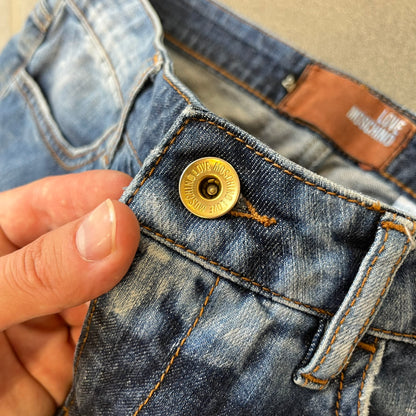 Love Moschino Hearts Bootcut Jeans feature blue denim with a white washed effect around the knees and a bootcut construction. They have a gold-tone Love Moschino button and two back pockets with raised horizontal heart-shaped stitching. Made from 98% cotton and 2% elastane.
