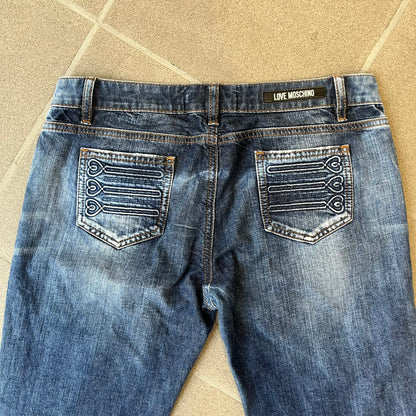 Love Moschino Hearts Bootcut Jeans feature blue denim with a white washed effect around the knees and a bootcut construction. They have a gold-tone Love Moschino button and two back pockets with raised horizontal heart-shaped stitching. Made from 98% cotton and 2% elastane.

