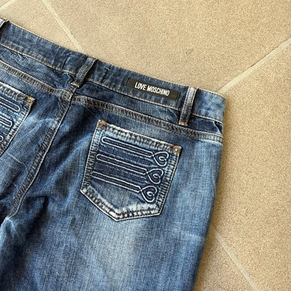 Love Moschino Hearts Bootcut Jeans feature blue denim with a white washed effect around the knees and a bootcut construction. They have a gold-tone Love Moschino button and two back pockets with raised horizontal heart-shaped stitching. Made from 98% cotton and 2% elastane.
