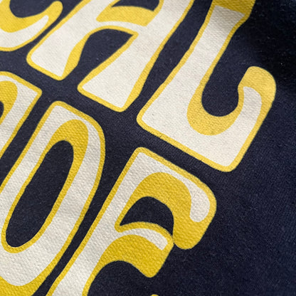 Lyrical Lemonade Everyday Essentials Yellow Logo Hoodie is a black pullover hoodie featuring a large two-tone yellow Lyrical Lemonade logo printed on the front. It includes an Everyday Essentials neck tag and classic comfortable hoodie construction.