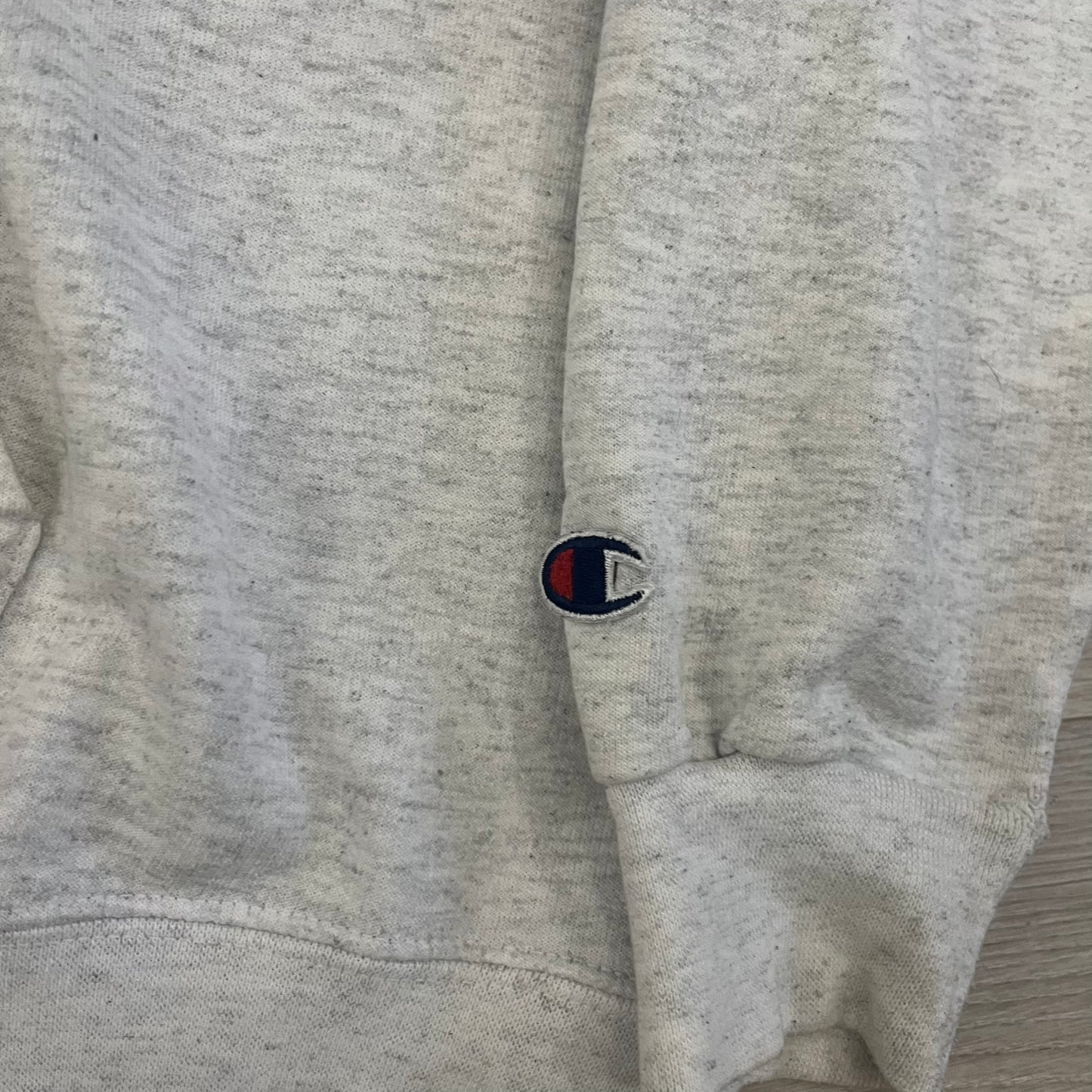 Champion x Lyrical Lemonade Grey Hoodie featuring a triple overlaping lemonade cartoon patch design on the front left chest. Made from a 50/50 cotton-polyester, this medium ash grey hoodie includes a two-ply hood, dyed-to-match drawcord, front pouch pocket, and embroidered Champion logo on the wrist.