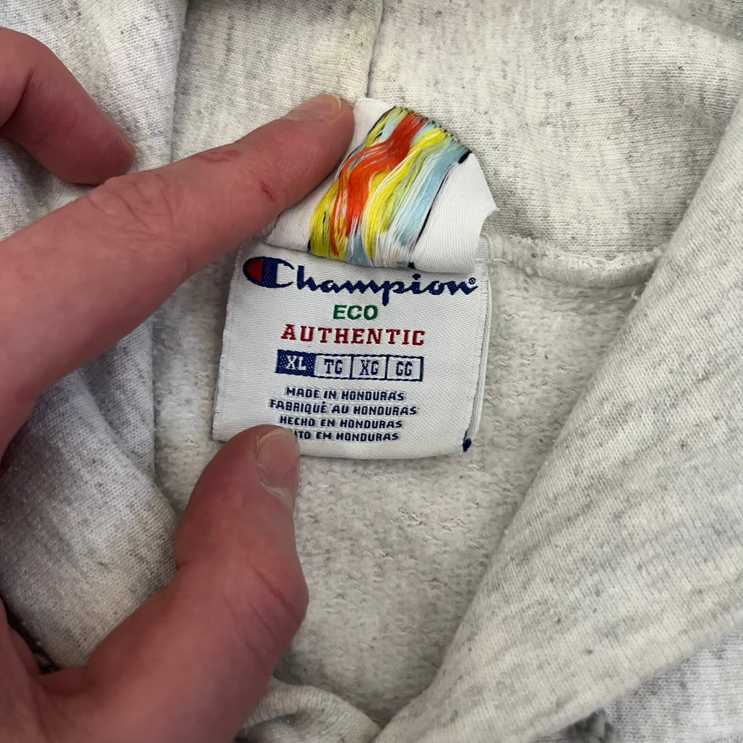 Champion x Lyrical Lemonade Grey Hoodie featuring a triple overlaping lemonade cartoon patch design on the front left chest. Made from a 50/50 cotton-polyester, this medium ash grey hoodie includes a two-ply hood, dyed-to-match drawcord, front pouch pocket, and embroidered Champion logo on the wrist.