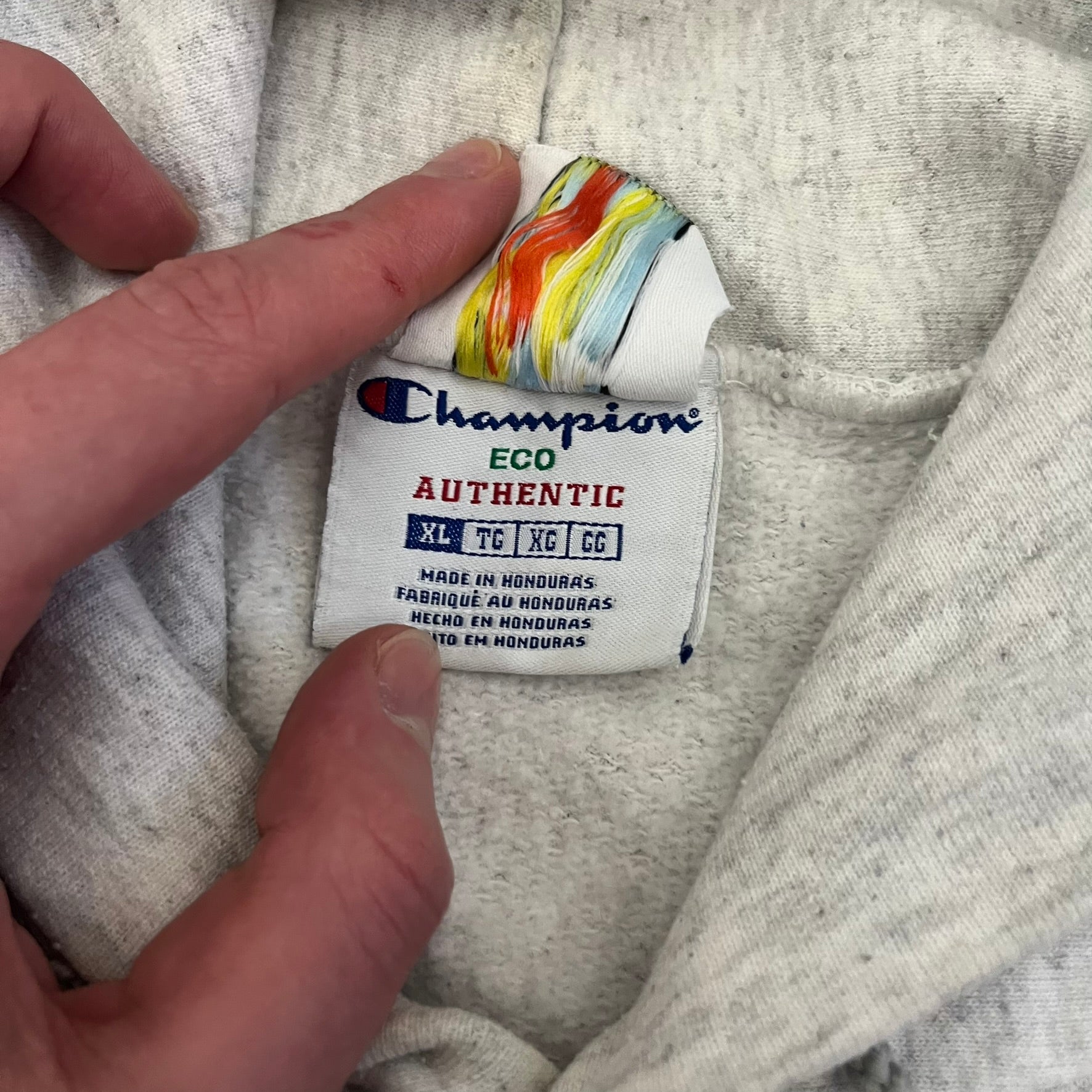 Champion x Lyrical Lemonade Grey Hoodie featuring a triple overlaping lemonade cartoon patch design on the front left chest. Made from a 50/50 cotton-polyester, this medium ash grey hoodie includes a two-ply hood, dyed-to-match drawcord, front pouch pocket, and embroidered Champion logo on the wrist.