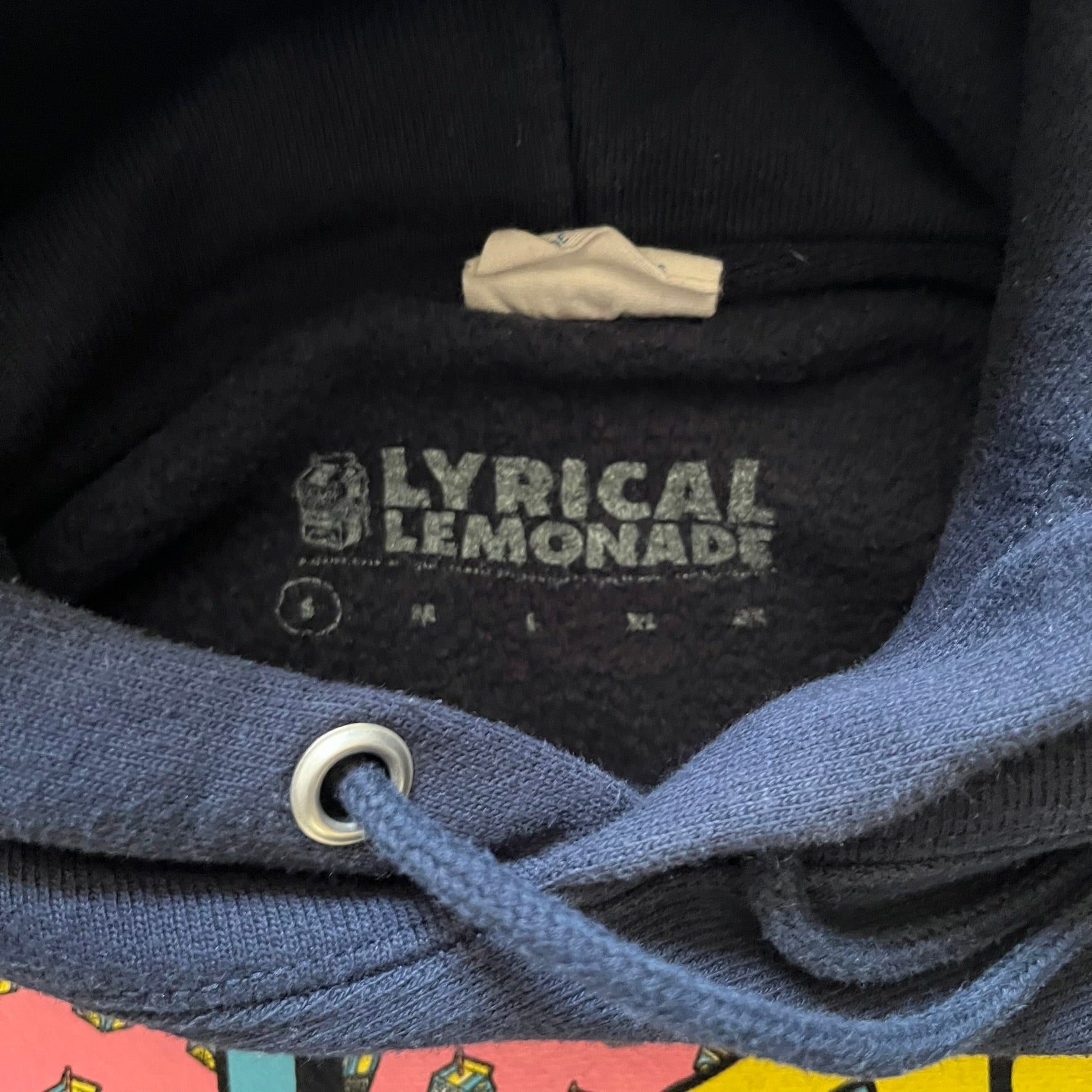 Lyrical Lemonade x MTV hoodie made on a Champion Reverse Weave blank. The front features a large pink Lyrical Lemonade “LL” logo based on MTV, filled with lemonade carton graphics, and white “Lyrical Lemonade” text printed underneath. Constructed with Champion’s heavyweight Reverse Weave fabric, finished with ribbed side panels and a small embroidered Champion logo on the sleeve near the hem.