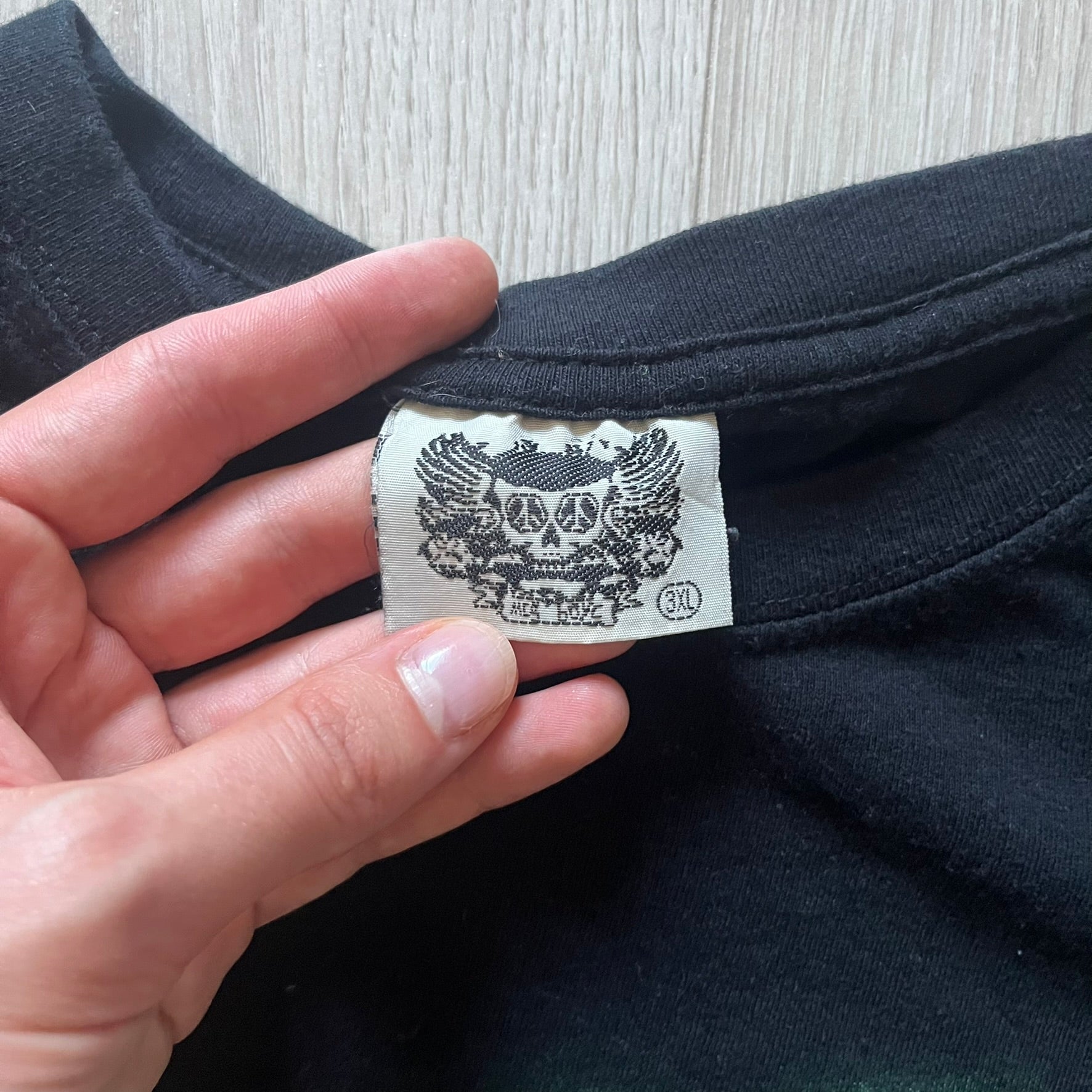 MC5 Boyc Skulls Tee in a wide, boxy-ish fit, crafted from high-quality cotton. The black tee features a large cracked skull with piercings on the front, surrounded by smaller skulls in white and green tones. A bold vintage-inspired graphic piece with strong visual impact.