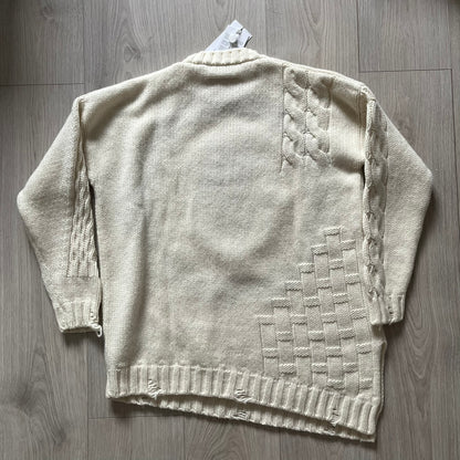 Beige knitted cardigan with geometric pattern on a wooden surface