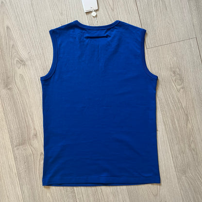 Blue sleeveless shirt on a wooden floor with a tag attached.