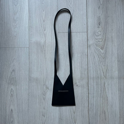 MM6 Maison Margiela Japanese 6 Accordion Phone Bag in black calf leather features a triangular silhouette, tonal stitching, and a single shoulder strap. Compact and structured, this Italian-made bag offers over-the-shoulder or crossbody wear, from the AW22 collection.