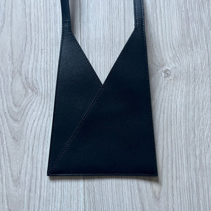 MM6 Maison Margiela Japanese 6 Accordion Phone Bag in black calf leather features a triangular silhouette, tonal stitching, and a single shoulder strap. Compact and structured, this Italian-made bag offers over-the-shoulder or crossbody wear, from the AW22 collection.