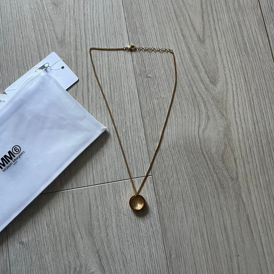MM6 Maison Margiela gold-tone necklace featuring a polished ring pendant engraved with the brand’s signature number logo. Made in Italy from brass, the design includes a cable-link chain with adjustable length and lobster clasp fastening. A refined accessory that blends subtle branding with timeless elegance.