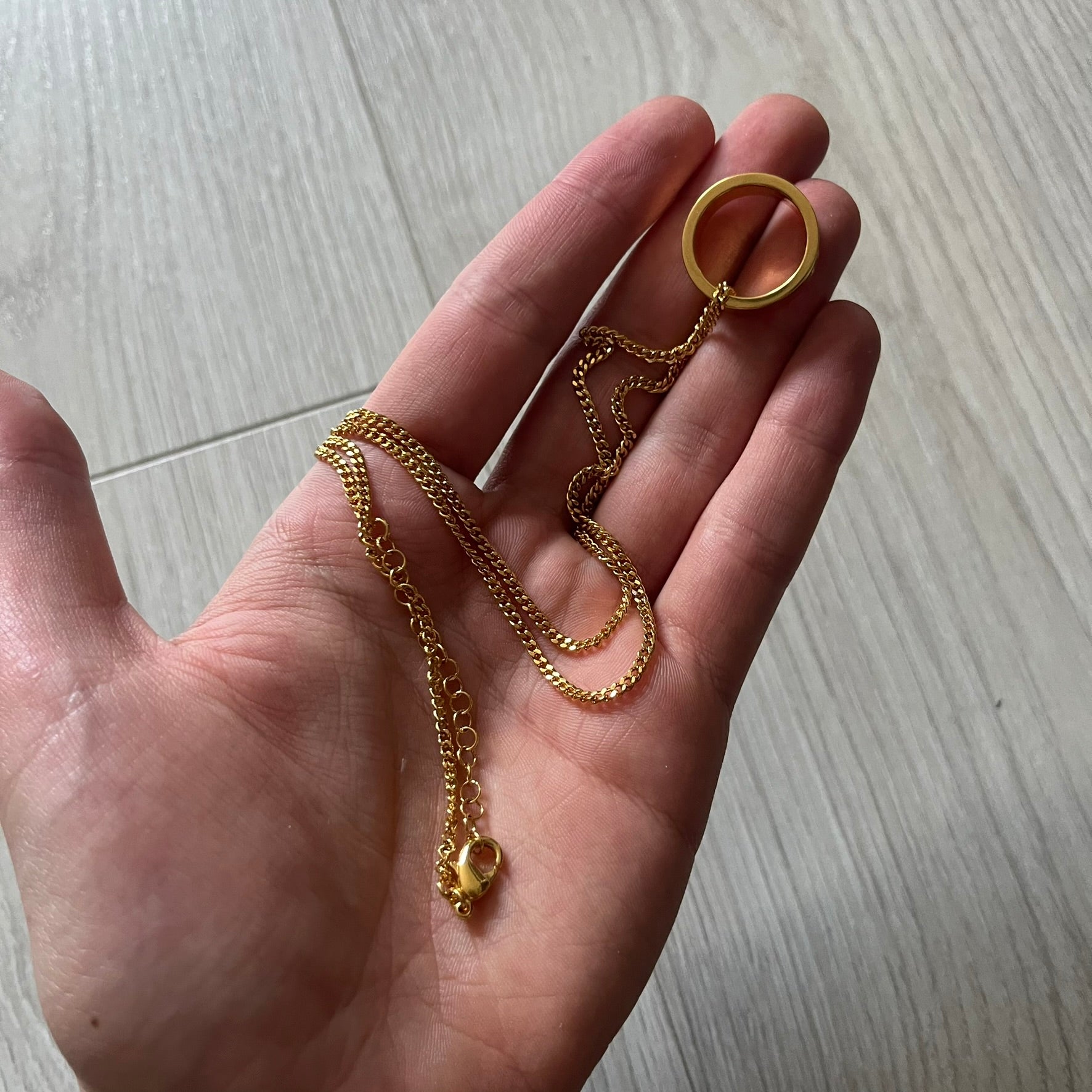 MM6 Maison Margiela gold-tone necklace featuring a polished ring pendant engraved with the brand’s signature number logo. Made in Italy from brass, the design includes a cable-link chain with adjustable length and lobster clasp fastening. A refined accessory that blends subtle branding with timeless elegance.