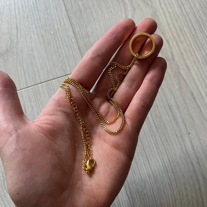 MM6 Maison Margiela gold-tone necklace featuring a polished ring pendant engraved with the brand’s signature number logo. Made in Italy from brass, the design includes a cable-link chain with adjustable length and lobster clasp fastening. A refined accessory that blends subtle branding with timeless elegance.