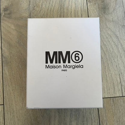 MM6 Maison Margiela White Side Cardholder is a white leather cardholder from MM6 Maison Margiela featuring a horizontal layout with a top zip compartment for coins. The side includes four card slots, while the front displays a mirrored Maison Margiela 6 logo. The item comes with original box and tags.