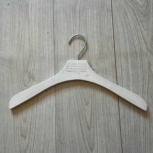 Maison Margiela x H&amp;M 2012 clothing hanger in a white-washed wood finish. Features a carved Margiela and H&amp;M logo with a clean, classic silhouette. Ideal for displaying tees, hoodies, or jackets with a touch of designer minimalism.
