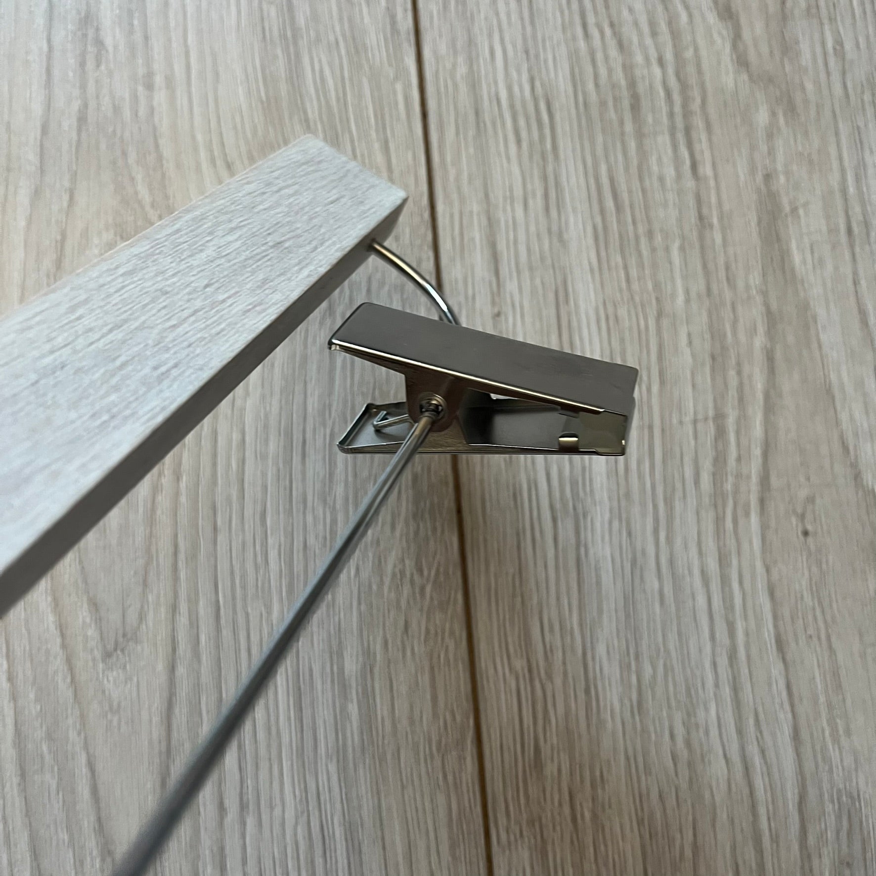 Maison Margiela x H&amp;M 2012 hanger in a white-washed wood finish with engraved logos. Features a straight wooden bar with metal clips, perfect for hanging pants, skirts, or shorts. A rare, functional collectible from this iconic collaboration.